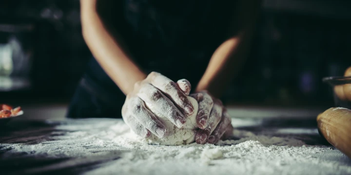 Woman kneads dough for make pizza on wooden. Cooking concept.