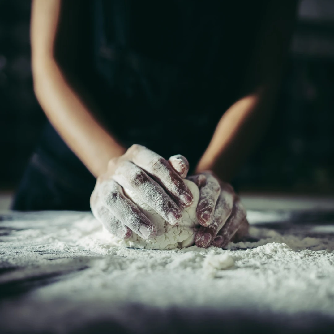 Woman kneads dough for make pizza on wooden. Cooking concept.